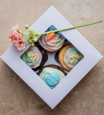 Box of cupcakes with flower on top